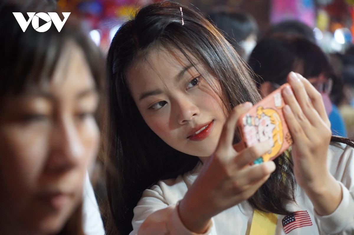 Young people enjoy taking selfies during the Full-Moon Festival celebrations.