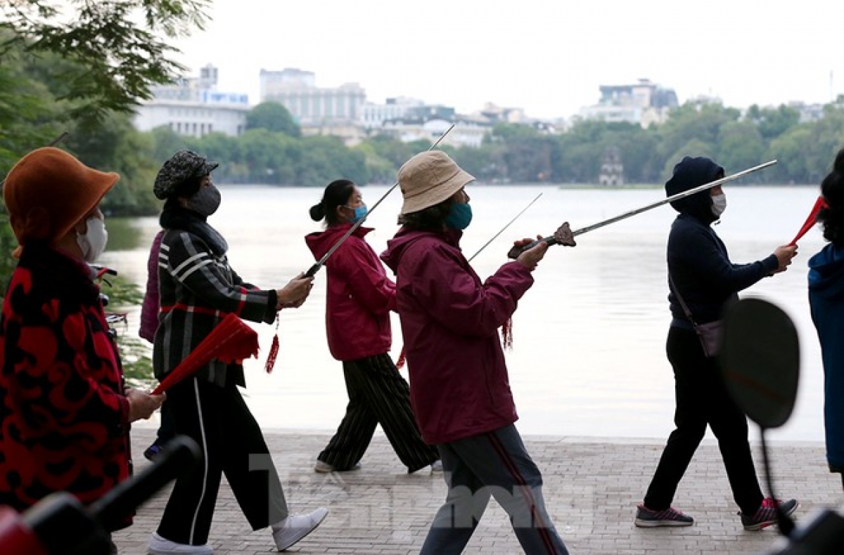 Elderly people wear jackets while taking part in their morning exercise routine.