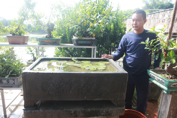 Mặt trước khắc hình chiếc khánh, bên trong có hình trái đào và hoa, ba mặt còn lại để trơn. Theo anh Tuấn, bể này các cụ xưa thường để đựng nước mưa.