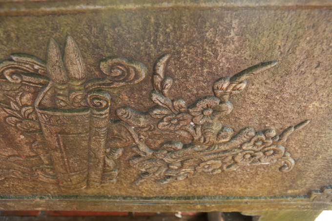 Một bên cuốn thư là hình ảnh con rồng thời Lý, phía trên  rồng có những cành mai