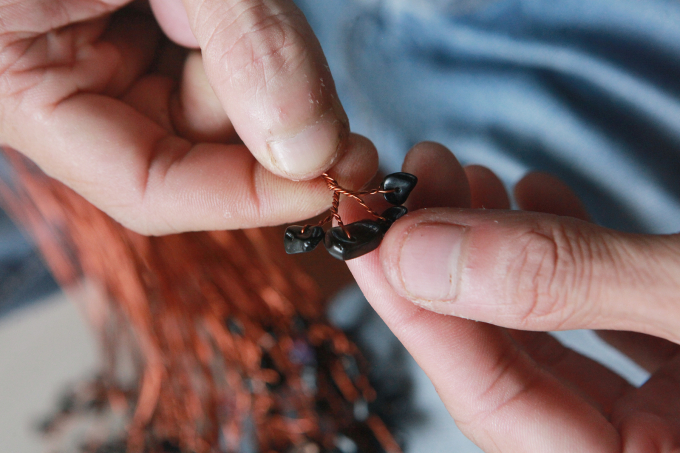 Tạo lá bằng cách xỏ hạt cườm vào dây đồng xong uấn thành hình lá, đây là cách tạo lá rất độc đáo mà anh Thành tự nghĩ ra