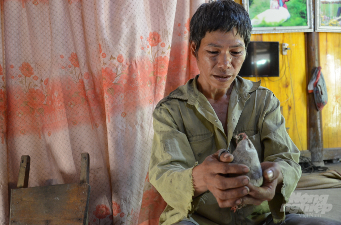 Anh Mùng Văn Chấn bên hòn đá thiêng. Ảnh: Dương Đình Tường.