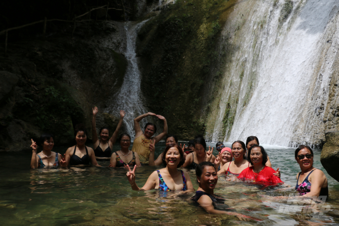 Đoàn khách của chị Nguyễn Thị Kim Dung đến từ câu lạc bộ Fami Yoga ở thị xã Phúc Yên, tỉnh Vĩnh Phúc bật cười khi ngâm mình dưới chân thác. Ảnh: Dương Đình Tường.