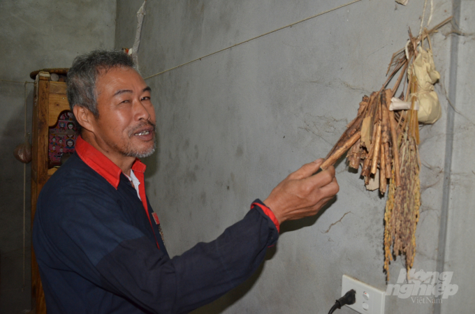 Ông Đặng Trung Hải cầm những vỏ cây rừng được đốt thay cho hương. Ảnh: Dương Đình Tường.