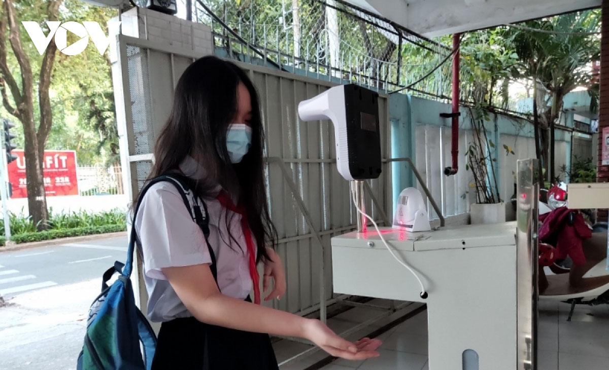 Students in Ho Chi Minh City strictly follow the Health Ministry's 5K practice, including wearing face masks and washing hands with sanitizer, before entering the classroom.