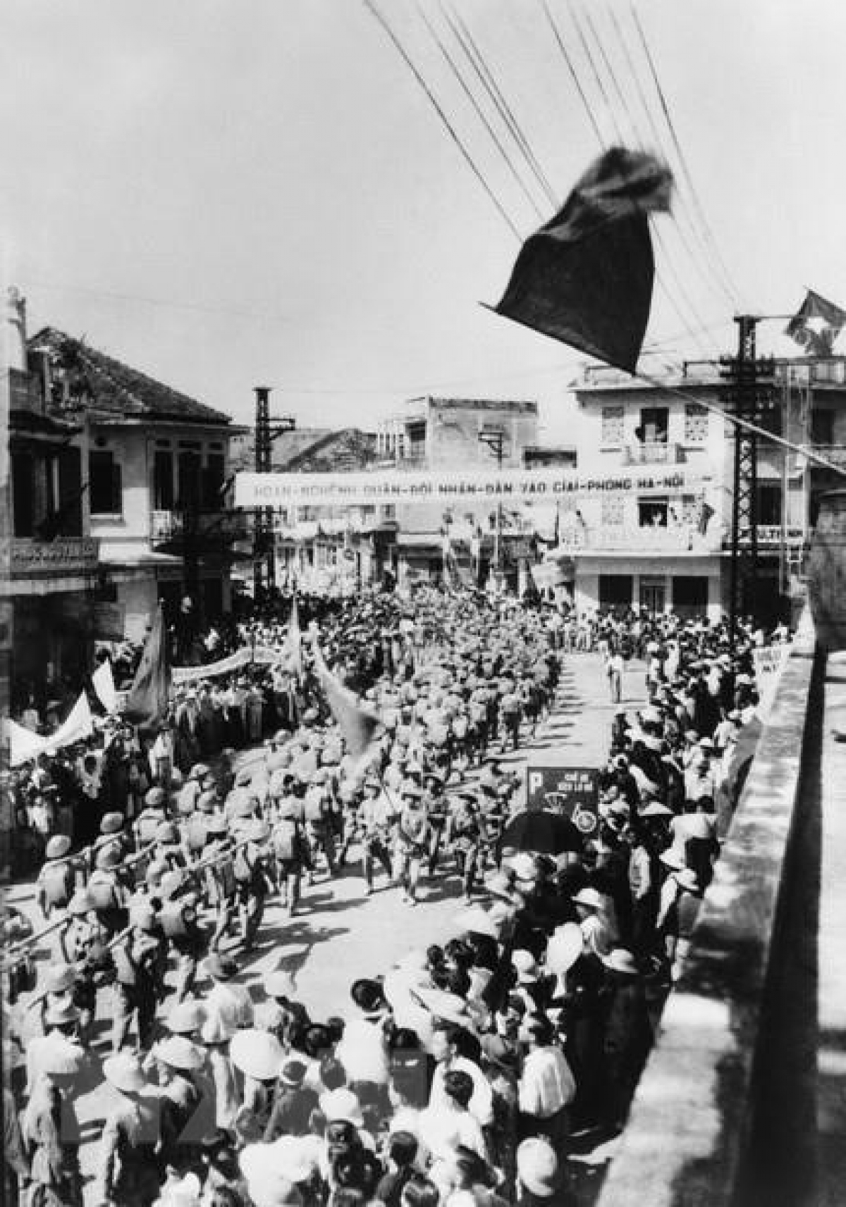 Approximately 200,000 residents bearing flags and flowers take to the streets to greet liberation forces. Pictured is the jubilant scenes on Hang Gai street.