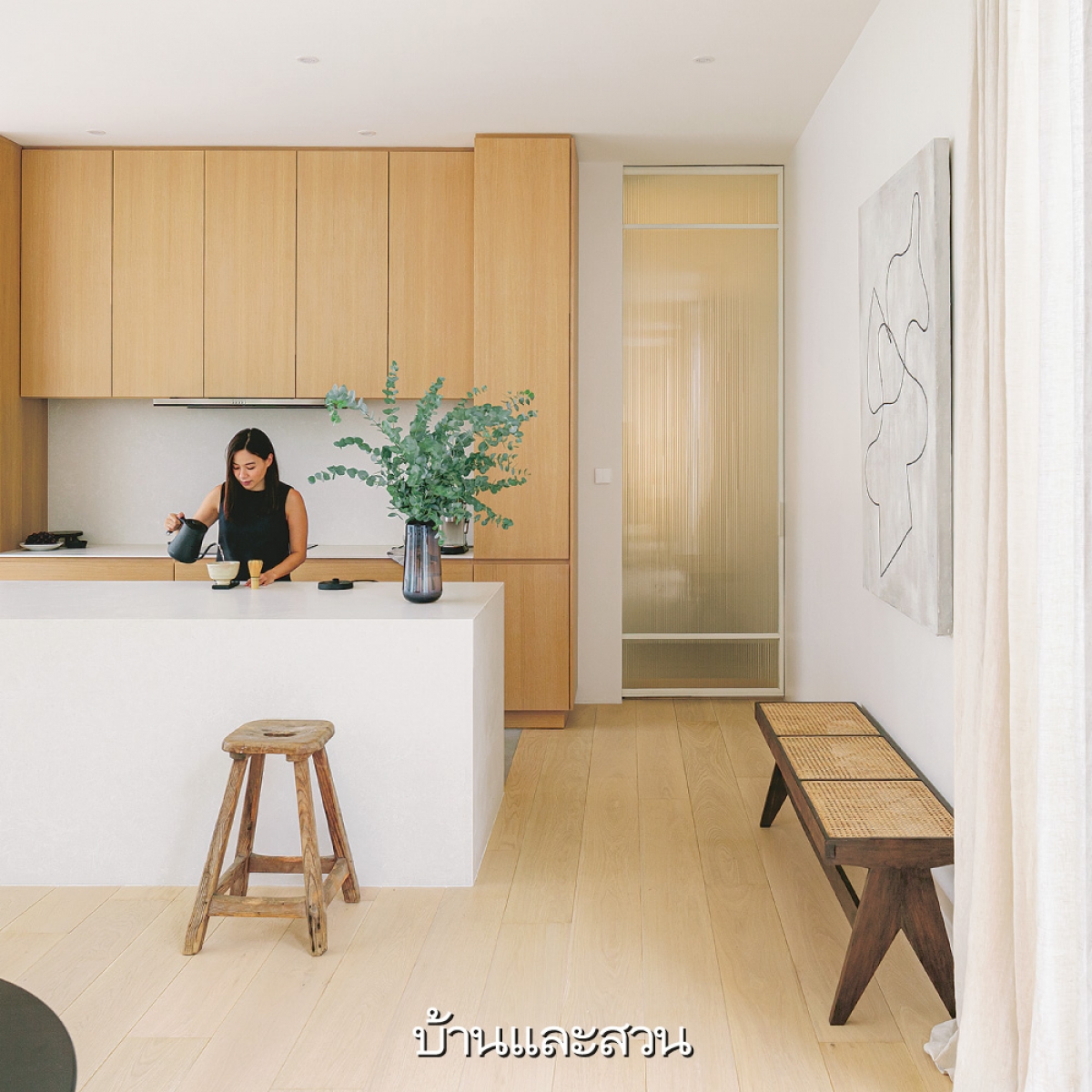 Một lọ cây xanh làm tăng sự sinh động hơn cho căn bếp tối giản chỉ với 2 màu gỗ và trắng.