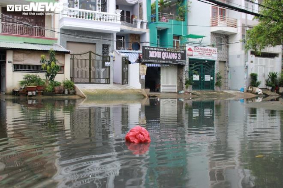 Triều cường làm nước ngập lênh láng, nhiều ngày không rút hết khiến nước cống hòa với nước triều cường đen kịt, bốc mùi.