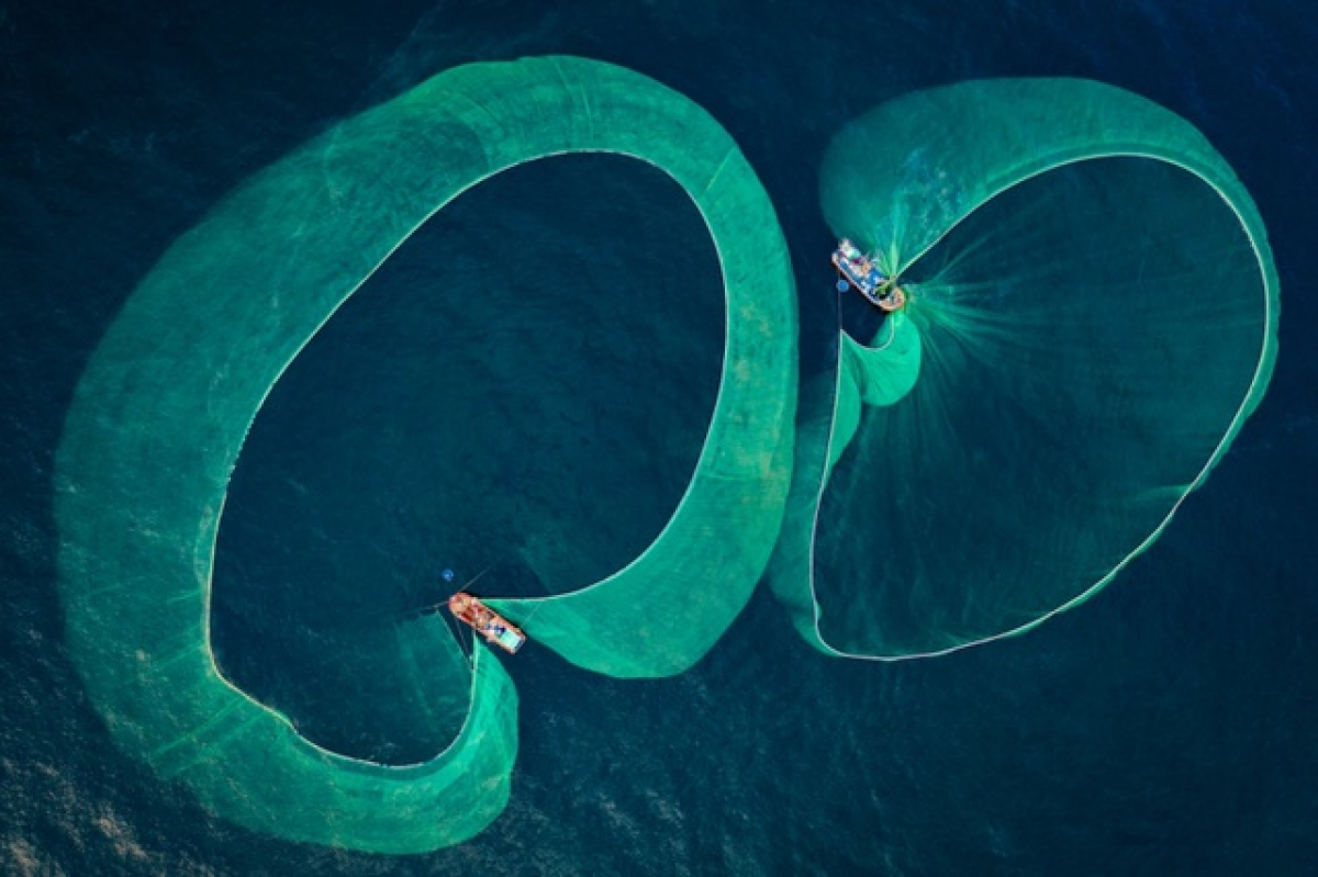 “Season of anchovy fishery” by Thien Nguyen features local fisherman as they catch anchovies in Phu Yen province. This image wins an award in the Journeys & Adventures category.