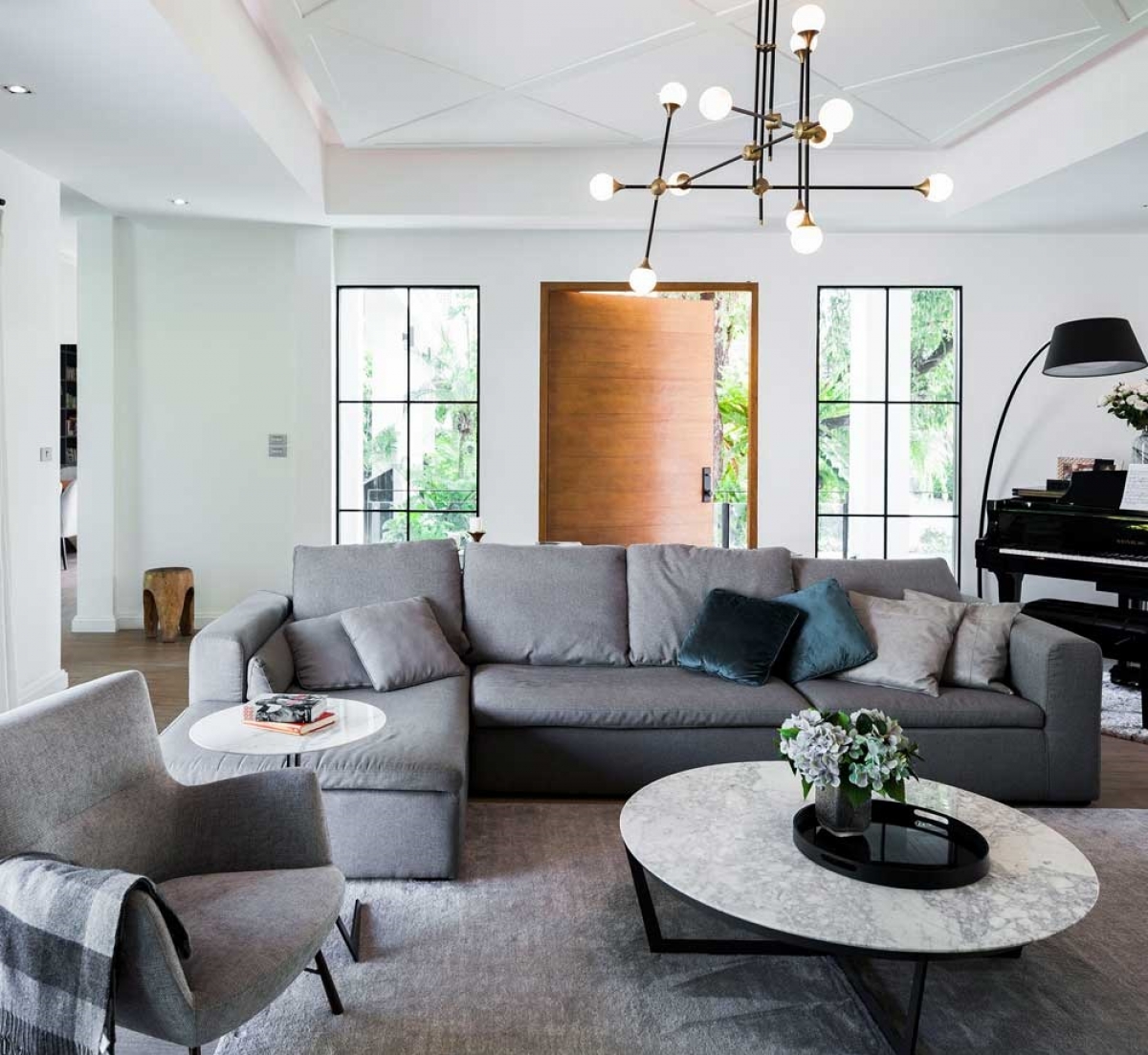 Sofa lớn kèm với tấm thảm cùng tông chiếm phần lớn diện tích phòng khách.