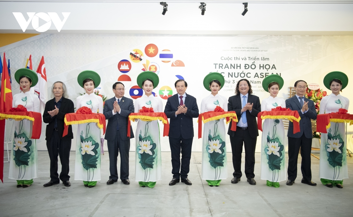Deputy Minister of Culture, Sports and Tourism Ta Quang Dong (C) joins with other delegates to cut the ribbon to mark the opening of the exhibition on November 6.