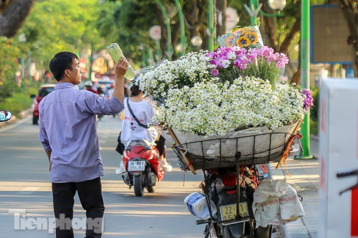 A seller pours water on the flowers to keep them fresh all day.