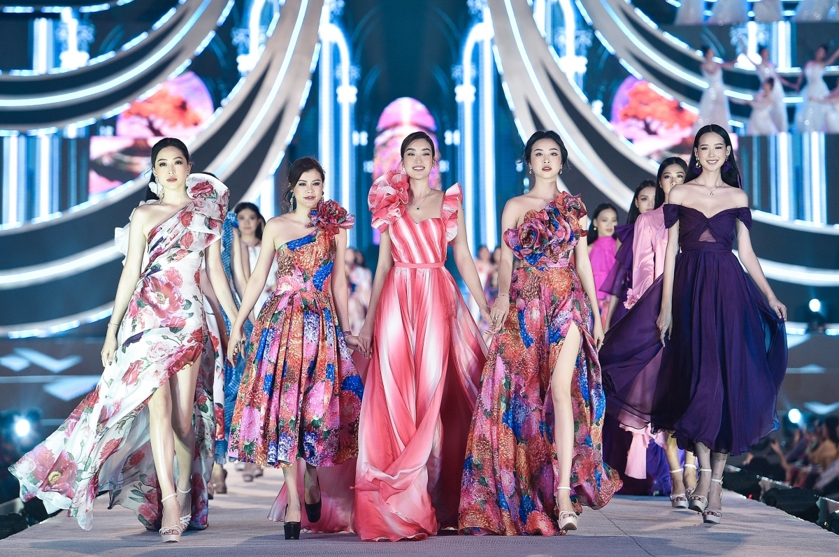 My Linh is joined by Phuong Nga (L) and Thuy An (fourth from left), two runners-up from the Miss Vietnam 2018 pageant, as they model designs from a collection on the theme of “The Most Beauty”.