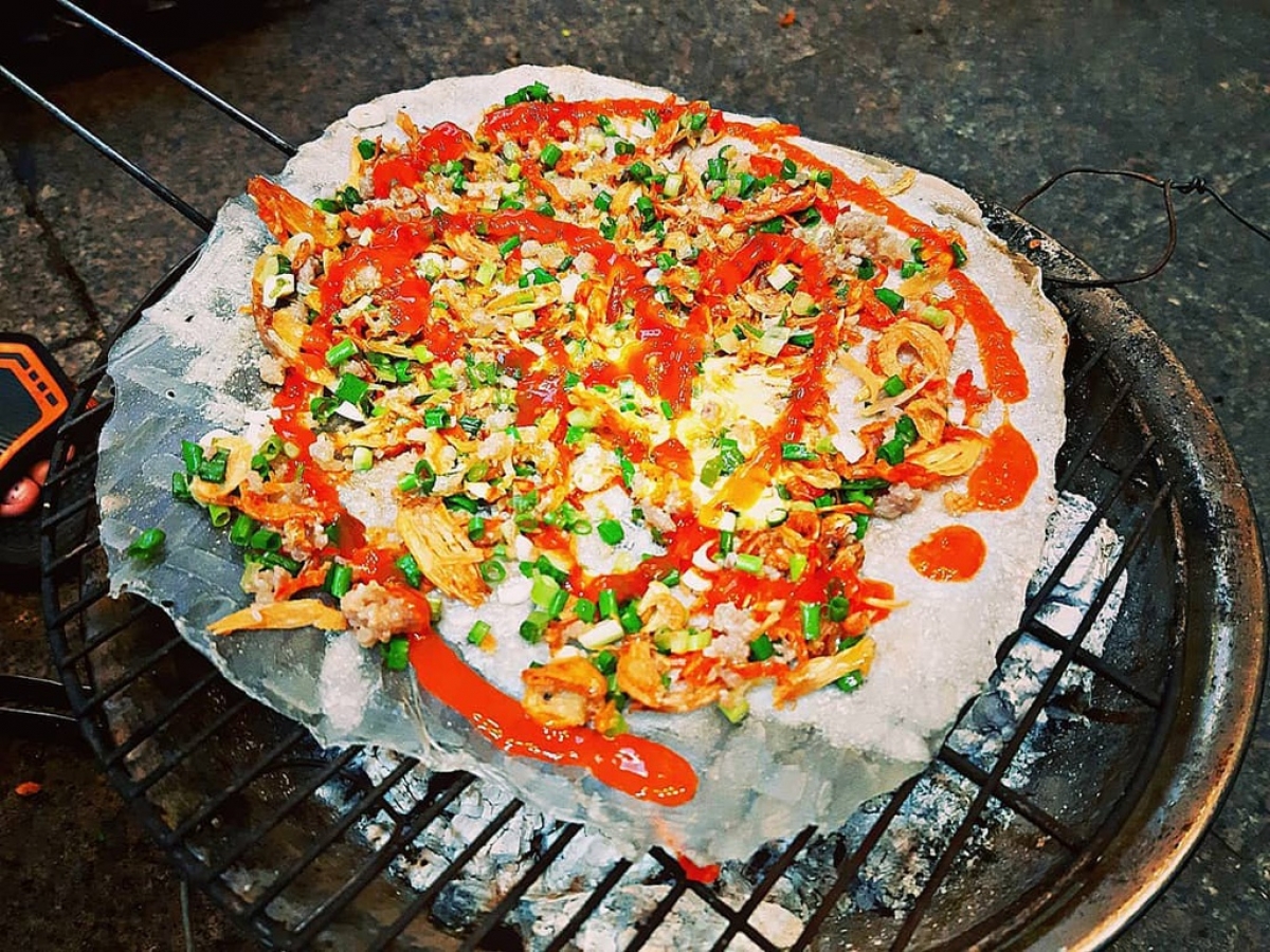 Banh trang nuong, grilled rice paper with egg, is a dish that originates from Da Lat city and is one of the most popular street foods in Ho Chi Minh City. A set of cakes is priced at approximately VND15,000, equal to US$0.65. (Photo: Phuongmaris_)