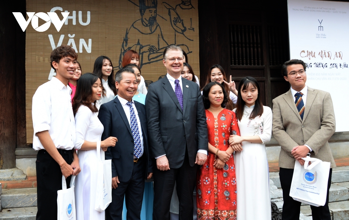 The US ambassador poses for a group photo alongside Vietnamese teachers and students at the site.